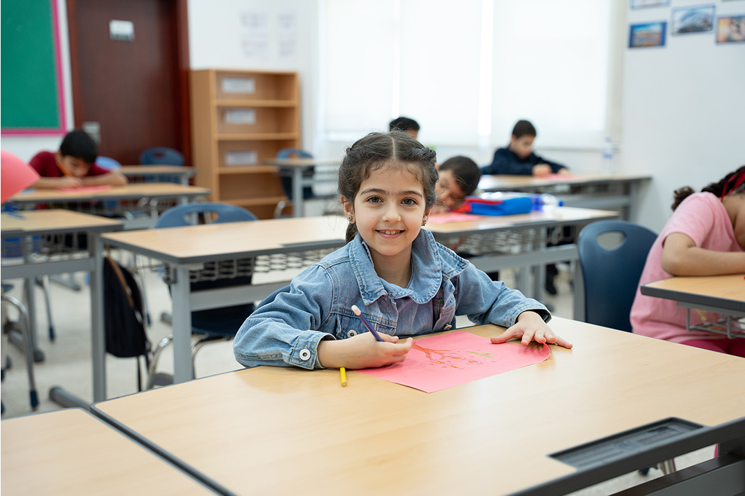 Happy child engaging in a Sandooq Al Watan community program